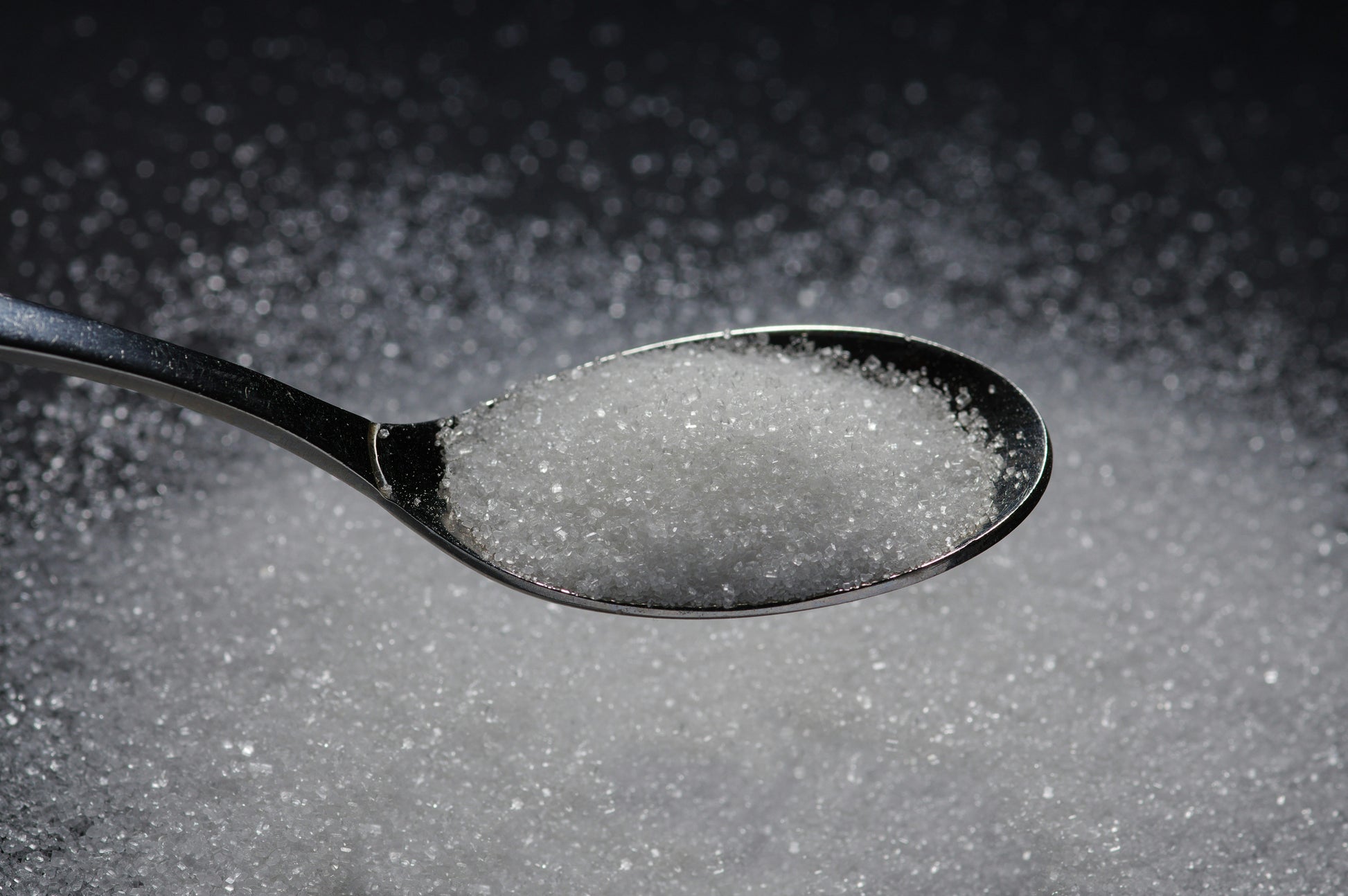 Spoonful of sugar on a dark background